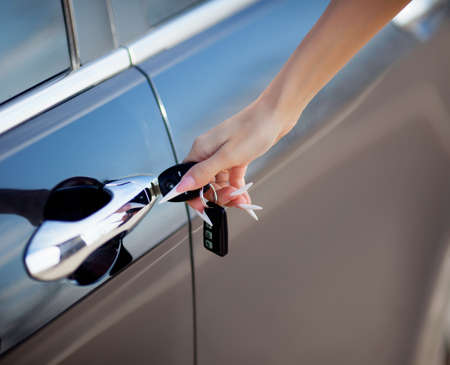 woman hand opening car door with keyの写真素材
