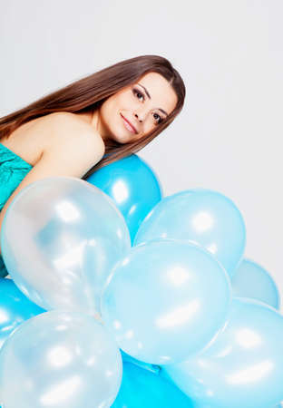 Beautiful brunette girl in studio with balloons on white background の写真素材
