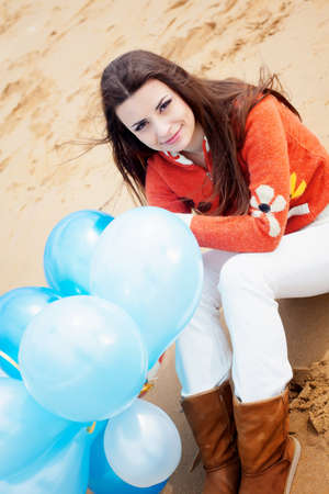 Girl on the beach with balloons in handの写真素材