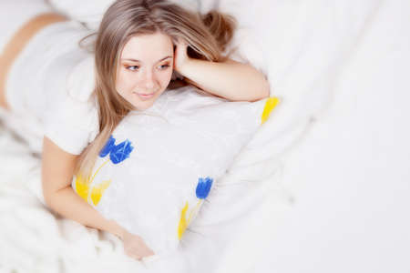 Young beautiful girl lying on the pillowの写真素材