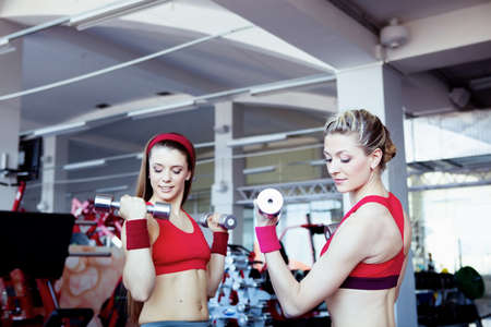 Two girls with dumbbells in hahds の写真素材