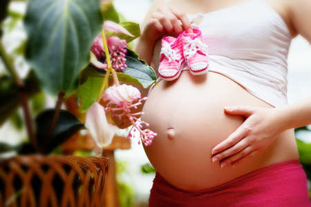 Beautiful pregnant woman sitting in garden