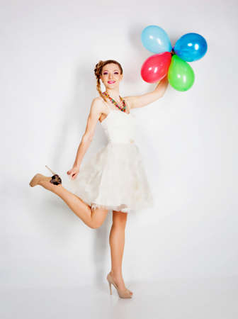 Smiling woman with balloons studio portraitの写真素材