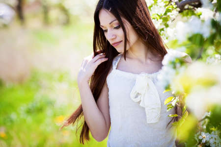 Beautiful brunette hair girl in blossom gardenの写真素材