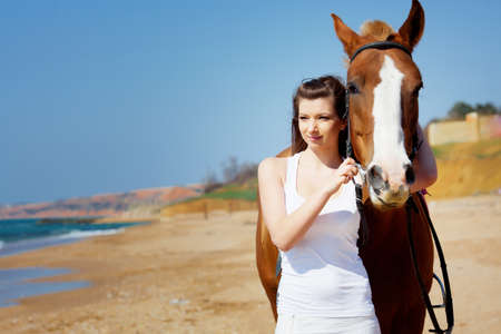 Girl with horse on the beachの写真素材