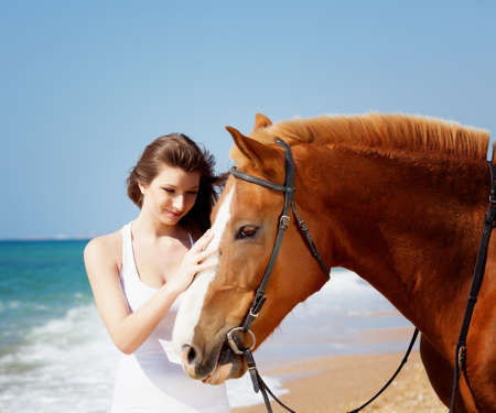 Girl with horse on the beachの写真素材