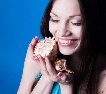 Beautiful girl with seashells in studioの写真素材