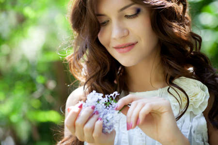 Beautiful girl with lilac flowerの写真素材