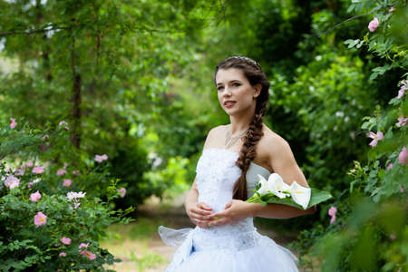 Beautiful brunette bride portrait in summer parkの写真素材
