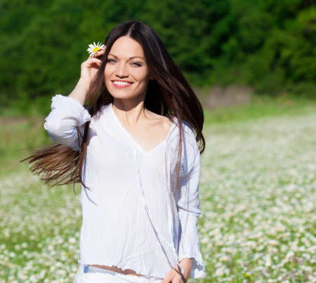 Brunette girl on the chamomile fieldの写真素材