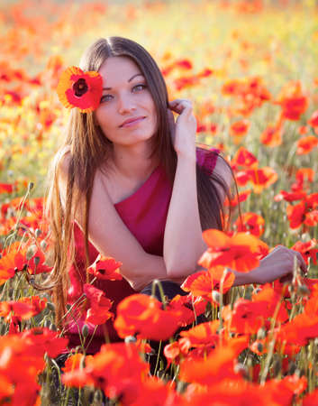 Beautiful girl in poppies meadowの写真素材