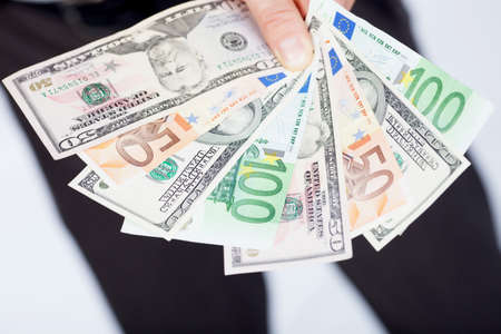 Dollars and euro currency in hand