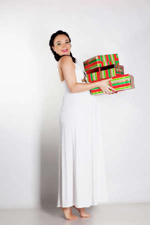 Beautiful pregnant woman with presents in handsの写真素材