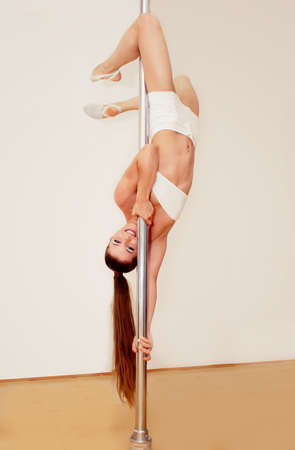 Beautiful girl making poledance figureの写真素材