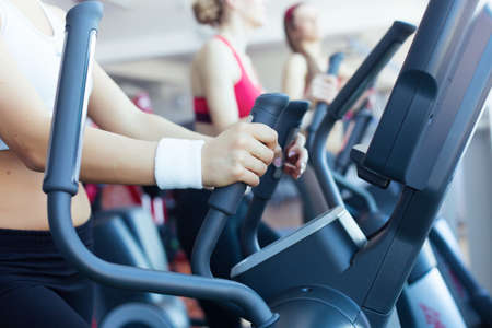 Woman hands on the running machine in fitness clubの写真素材
