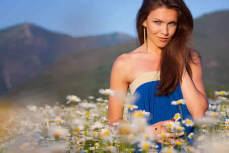 Girl in blue dress on camomile meadowの写真素材