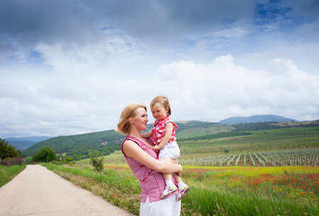 Mother with daughter on the road near the meadowの写真素材