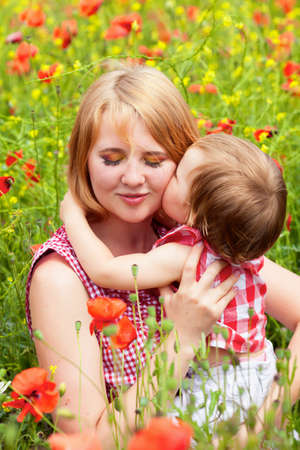 Mother with daughter on the poppy meadowの写真素材