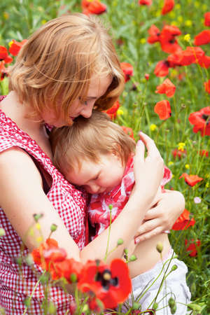 Mother with daughter on the poppy meadowの写真素材