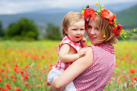 Mother with daughter on the poppy meadowの写真素材