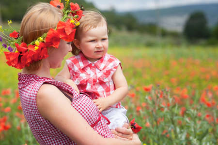 Mother with daughter on the poppy meadowの写真素材