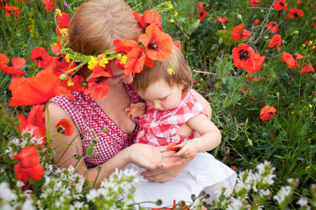 Mother with daughter on the poppy meadowの写真素材