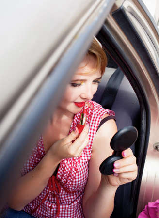 Woman with lipstick in the carの写真素材