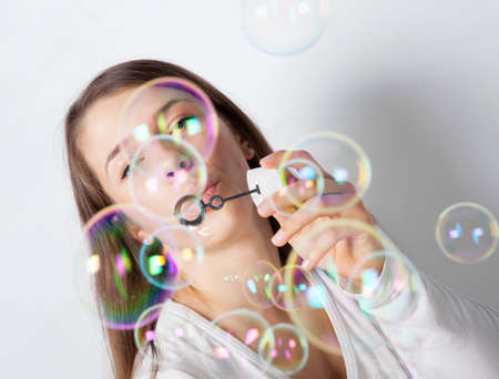 Girl making soap bubbles in studioの写真素材