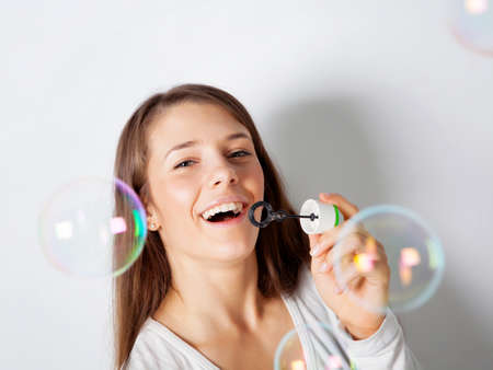 Girl making soap bubbles in studioの写真素材