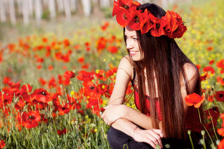 Beautiful girl on the poppy meadowの写真素材