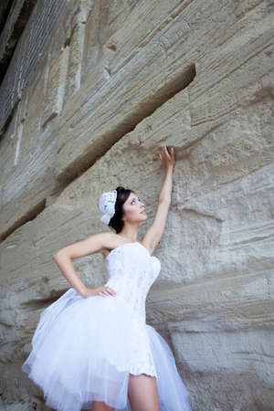 Beautiful bride outdoor portrait near high stone wallの写真素材