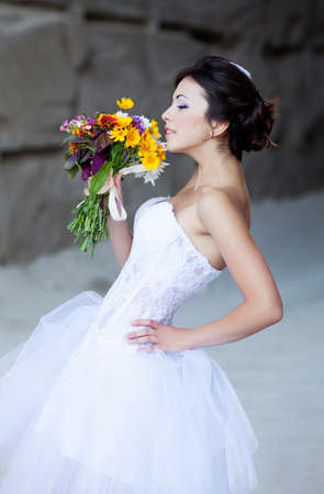 Beautiful bride outdoor portrait near high stone wallの写真素材