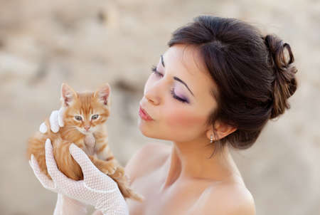 Bride holding ginger kitten in handsの写真素材