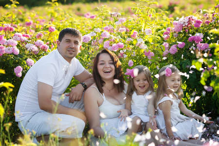 Family in rose flowers gardenの写真素材