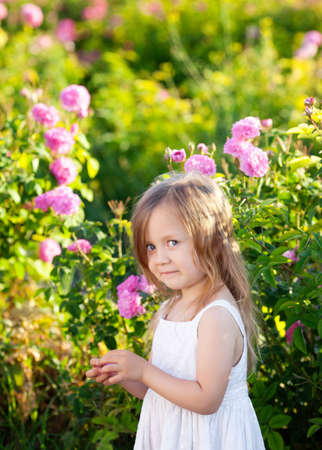 Girl playing in rose gardenの写真素材