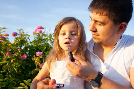 Father with daughter in rose flowers gardenの写真素材