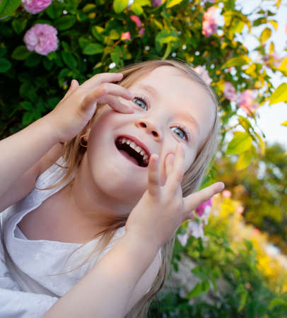 Girl playing in rose gardenの写真素材