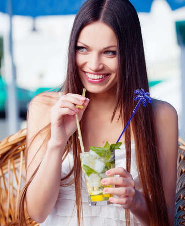 Beautiful girl with mojito drink in cafeの写真素材