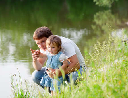 Father with daughter near the lakeの写真素材