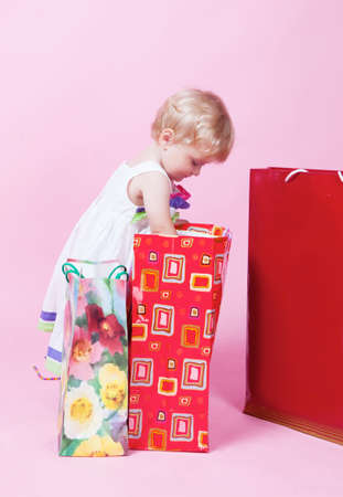 Little girl with color packages in studioの写真素材