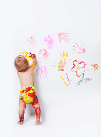 Little girl painting on the walls and floor in studioの写真素材