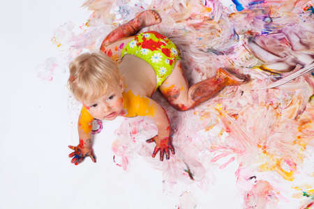 Little girl painting on the walls and floor in studioの写真素材