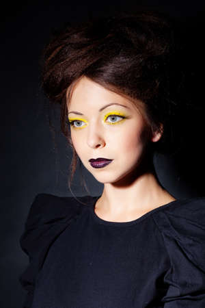 Woman with bright makeup in black dressの写真素材