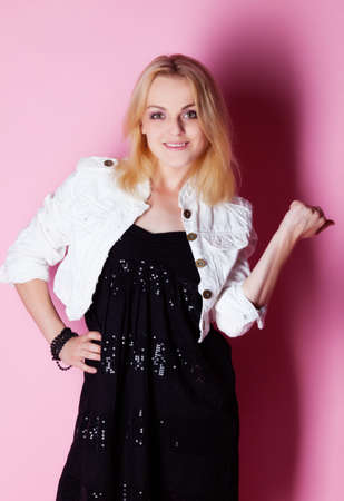 Girl in black dress isolated on pink backgroundの写真素材