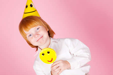 Red hair boy with candy in studioの写真素材