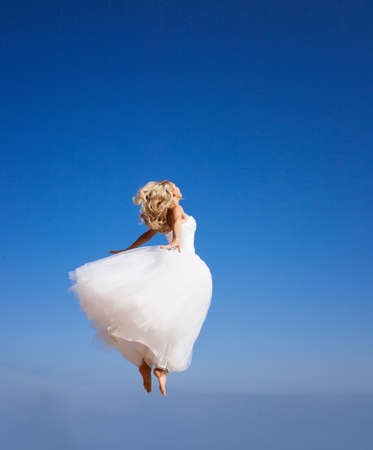 Beautiful bride jumping to the skyの写真素材