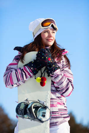 Beautiful girl in winter forest with snowboardの写真素材