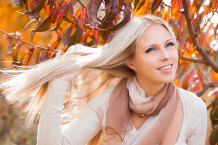 Beautiful blond woman portrait in autunm gardenの写真素材