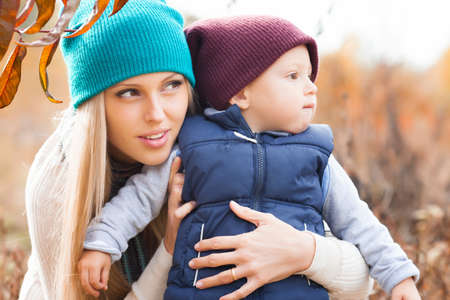 Mother with son in autumn peach gardenの写真素材