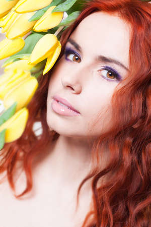 Beautiful woman with yellow tulip flowersの写真素材